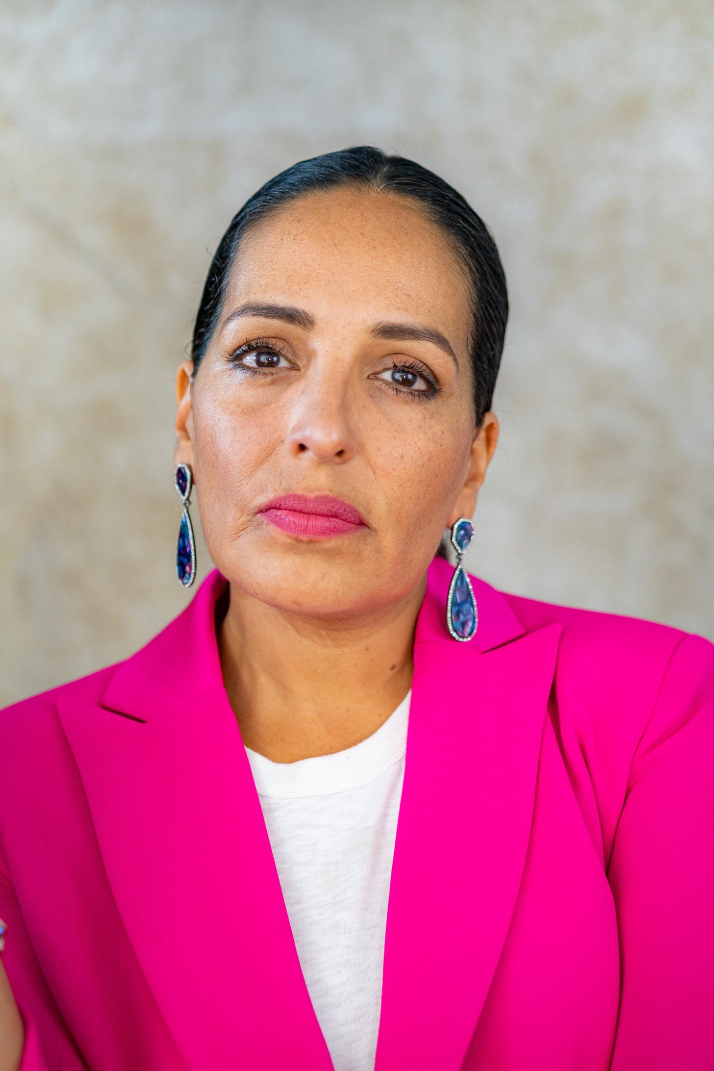 Alma Blue in a pink blazer — studio portrait